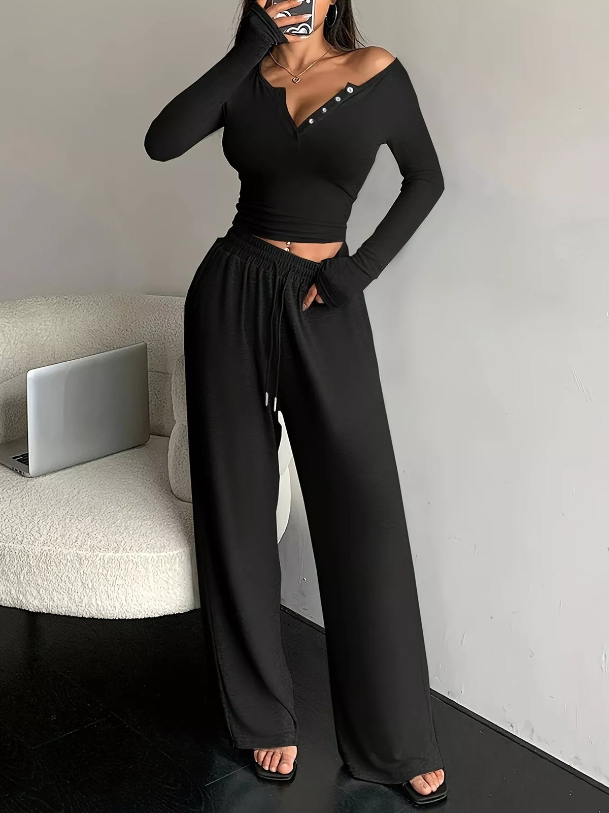 Front view of black two-piece set with buttoned neckline and drawstring pants