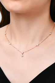 Close-up of spaced stones on a fine silver-tone necklace worn at the neckline