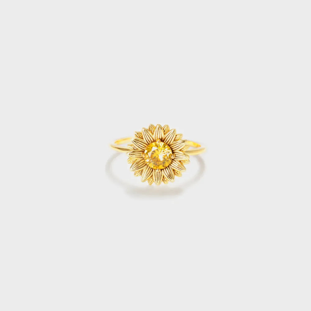 Single gold-tone sunflower ring with a yellow center on white