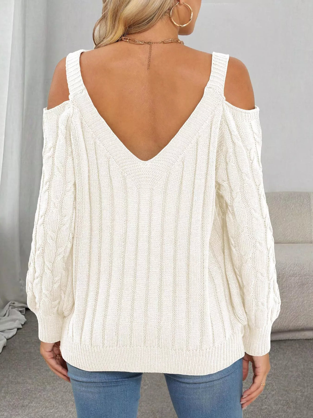 Back view of white sweater with V-shaped neckline and shoulder cutouts