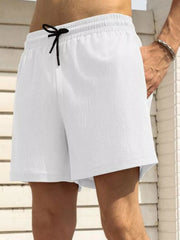 Model wearing white drawstring shorts, front view