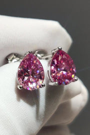 Pink teardrop stud earrings resting on a white display