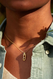 Model wearing gold-tone open rectangular pendant necklace