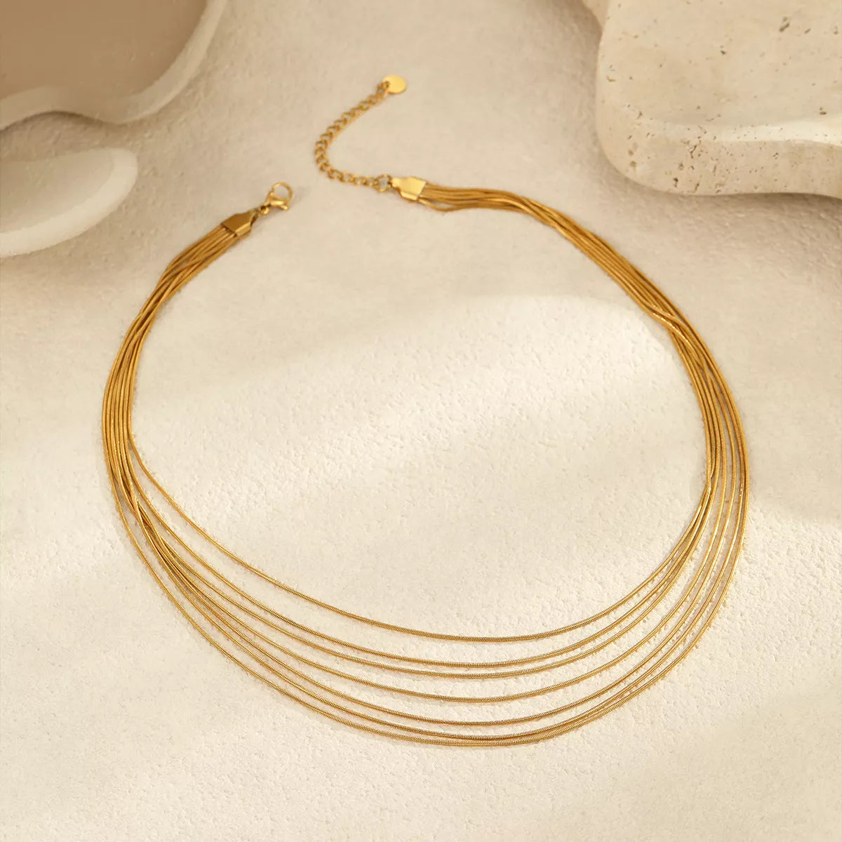 Gold-tone multi-strand necklace displayed on white