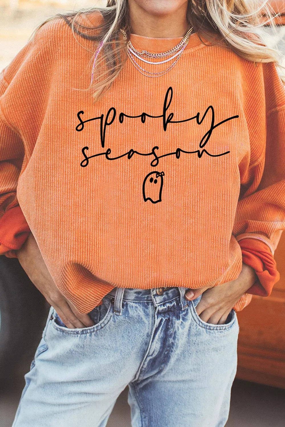 Close-up of spooky season lettering and small ghost graphic on sweatshirt