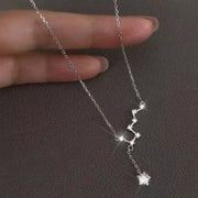 Hand holding silver chain with star-shaped charms