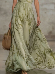 Close view of the flowing leaf-print skirt and fabric of the maxi dress.