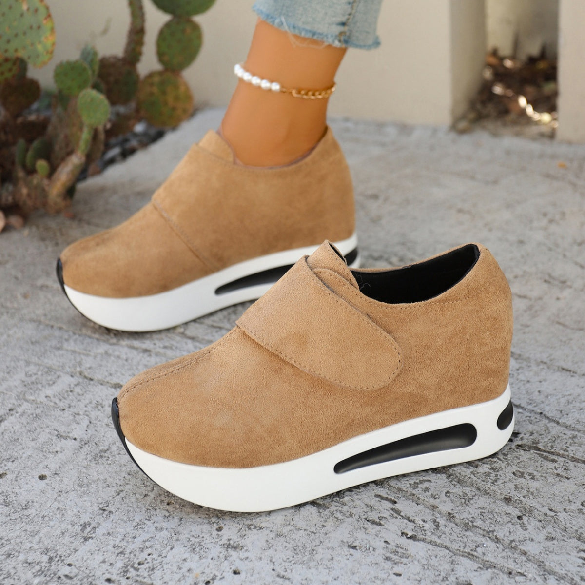 Pair of tan slip-on platform sneakers, side view