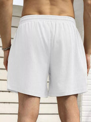 Model wearing white drawstring shorts, back view