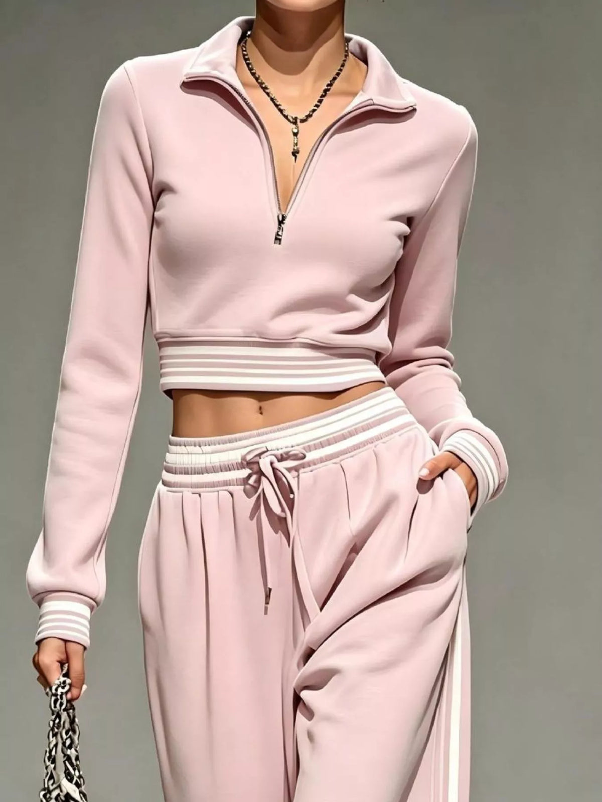 Close view of pink half-zip crop top with striped hem and cuff details