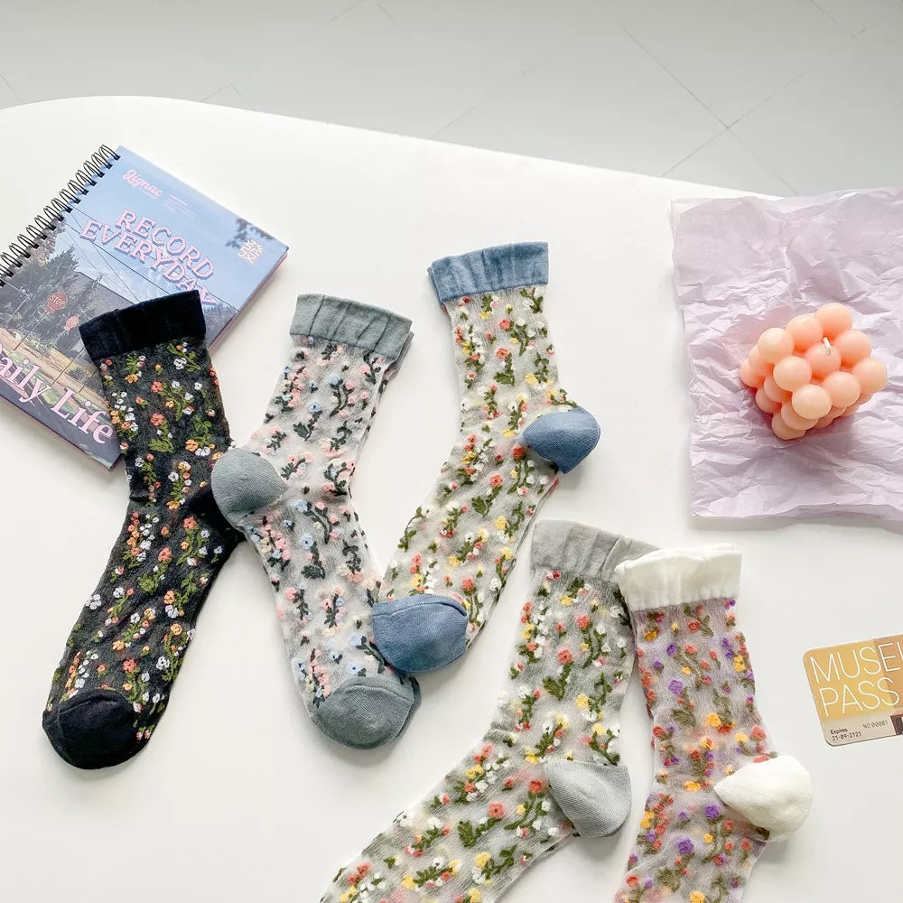 Floral sheer crew socks crossed and arranged to show colored toes and cuffs