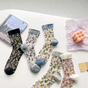 Floral sheer crew socks crossed and arranged to show colored toes and cuffs