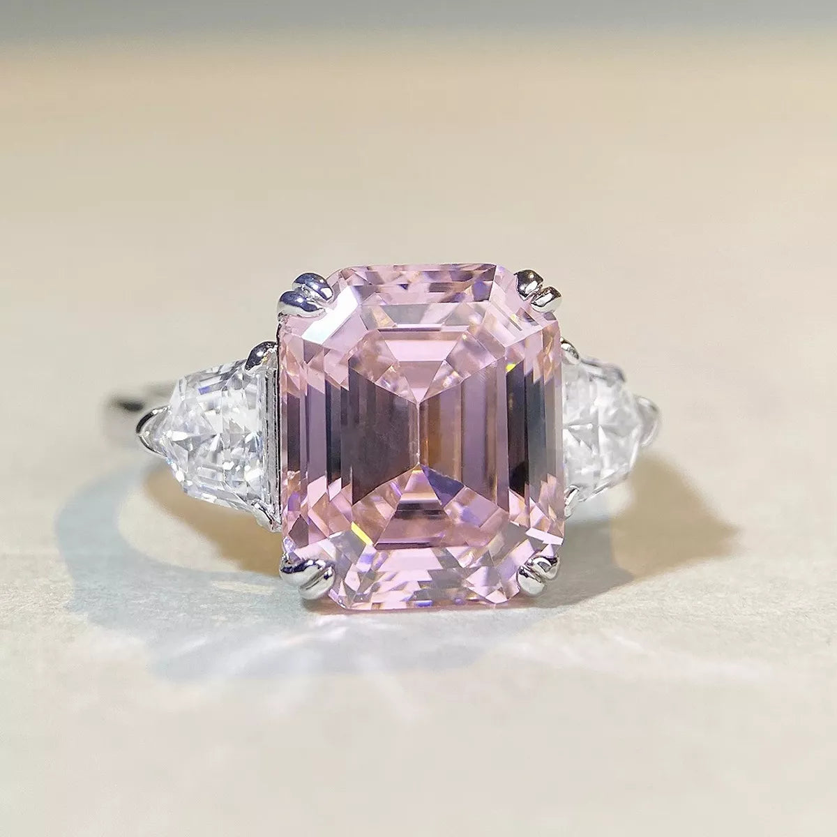 Front close-up of a blush pink rectangular zircon ring with clear triangular side stones