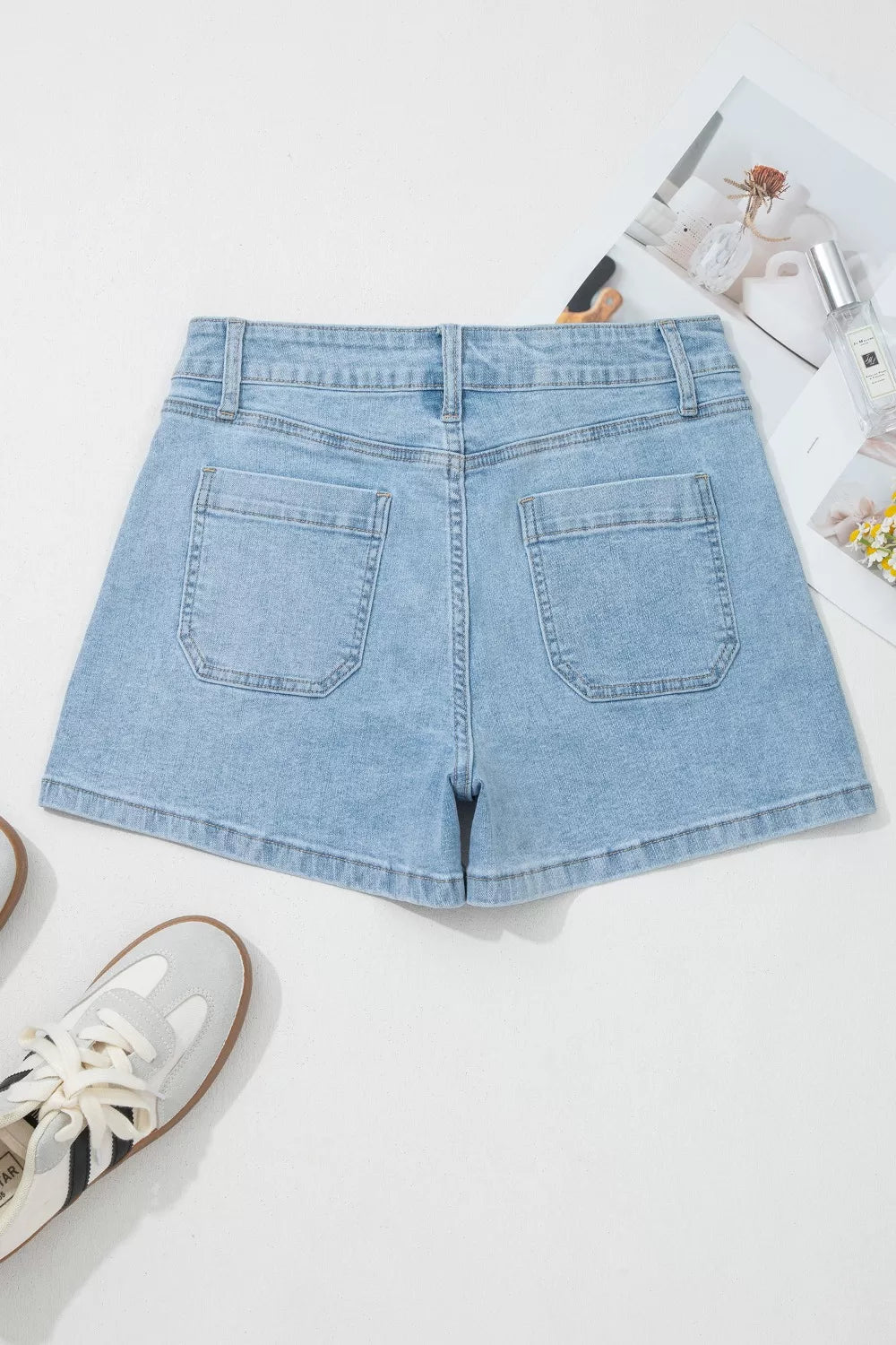 Front view of light-blue patch-pocket shorts laid flat
