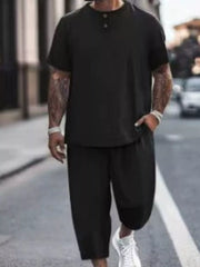 Model wearing black short-sleeve top and cropped pants