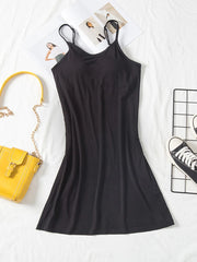 Black cami dress shown full length with round neckline and slim straps