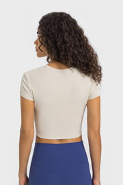 Back view of ivory cropped T-shirt paired with blue leggings