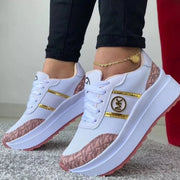 White and pink patterned platform sneakers on feet