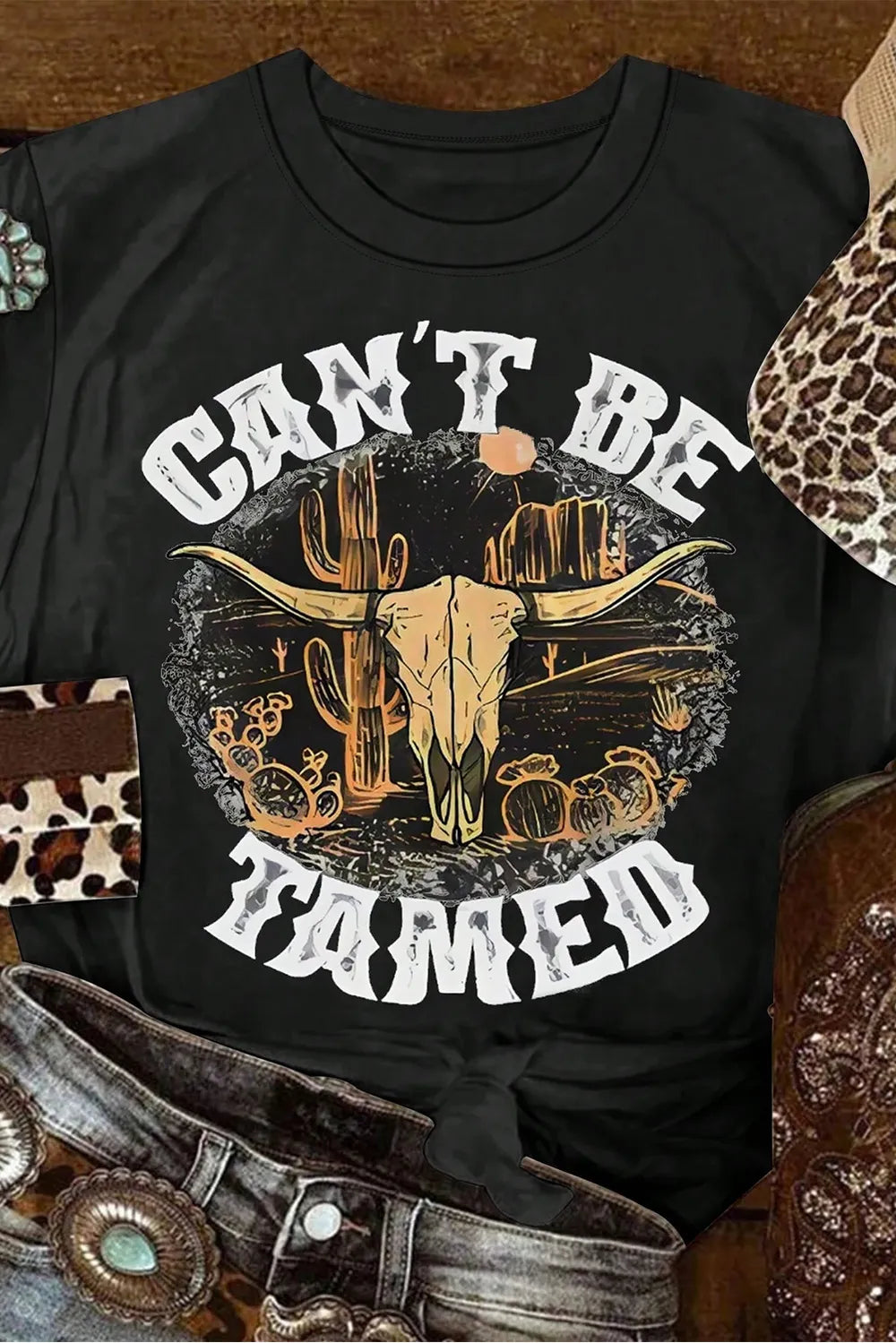 Close-up of Cant Be Tamed graphic on black T-shirt