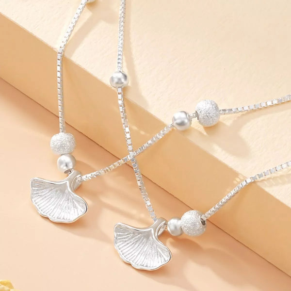 Close-up of ginkgo leaf charms and textured beads on the double-layer bracelet