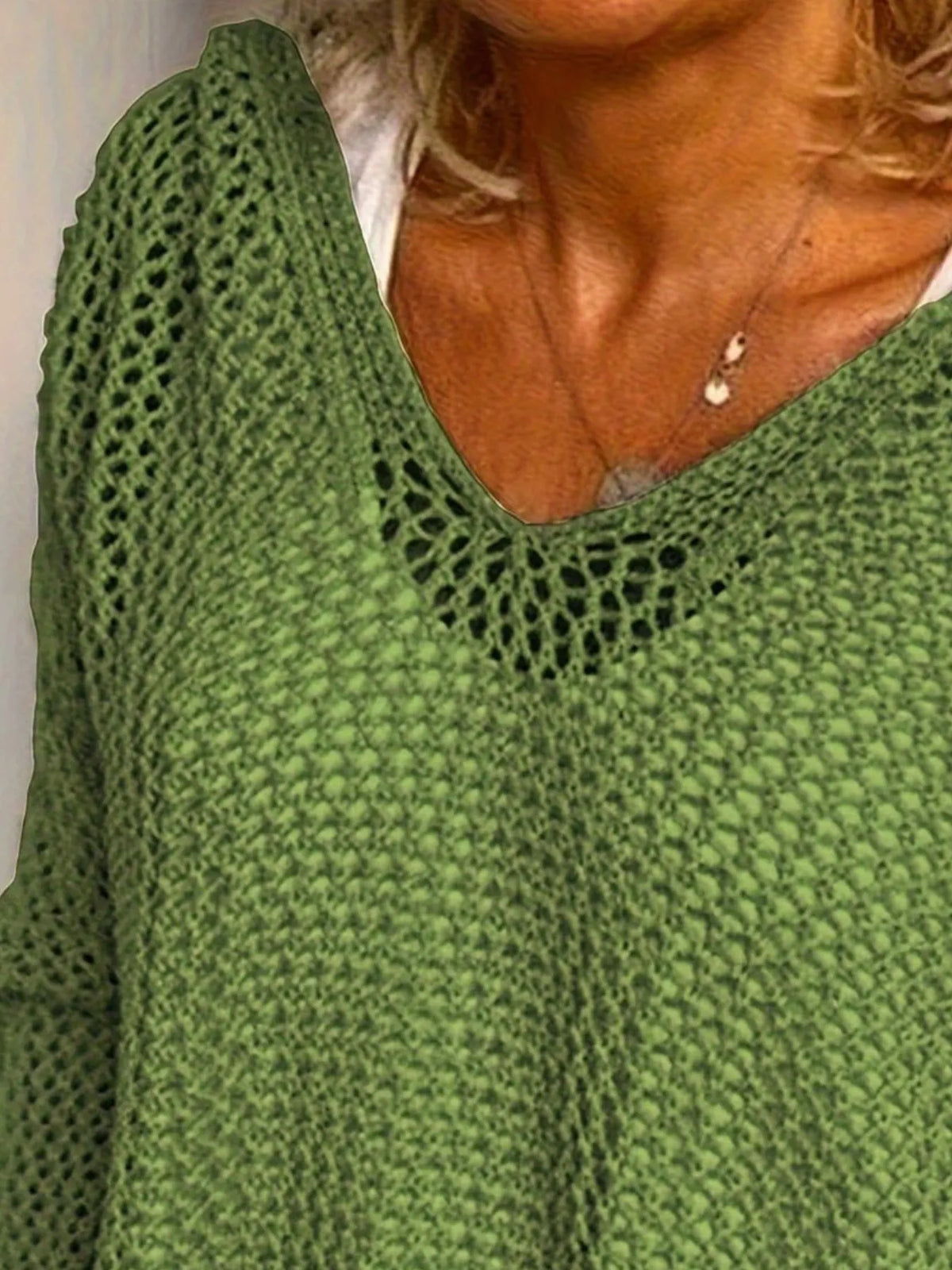 Green knit cover-up shown from neckline to lower front, with its loose open weave visible.