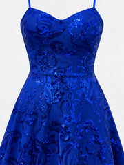 Close-up of the royal blue dress's shaped bodice, waist seam and floral-sequin pattern.