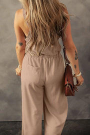 Khaki textured jumpsuit, model back view with shoulder bag