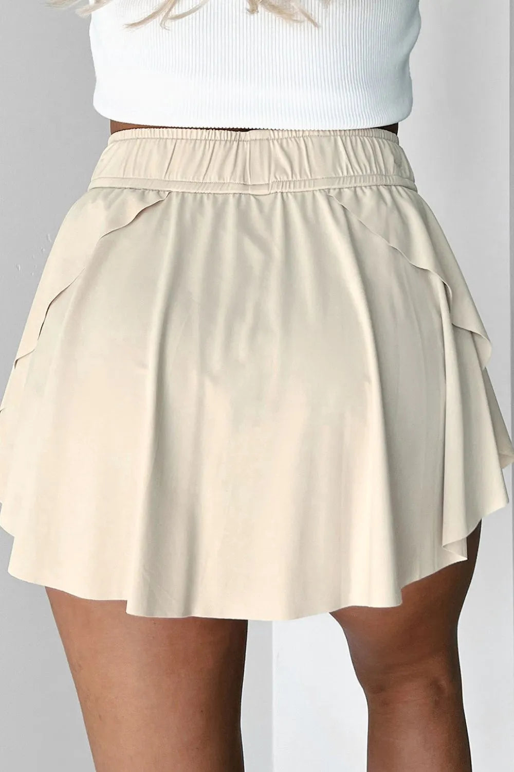 Back view of ivory skort with layered flounce panels and elastic waist.