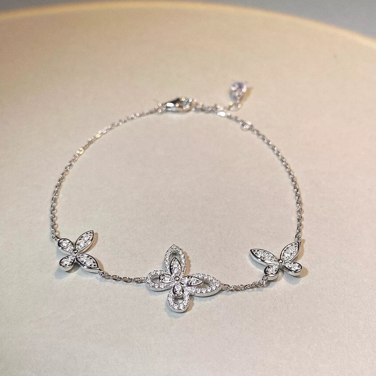 Silver-tone butterfly chain bracelet laid flat on a light surface