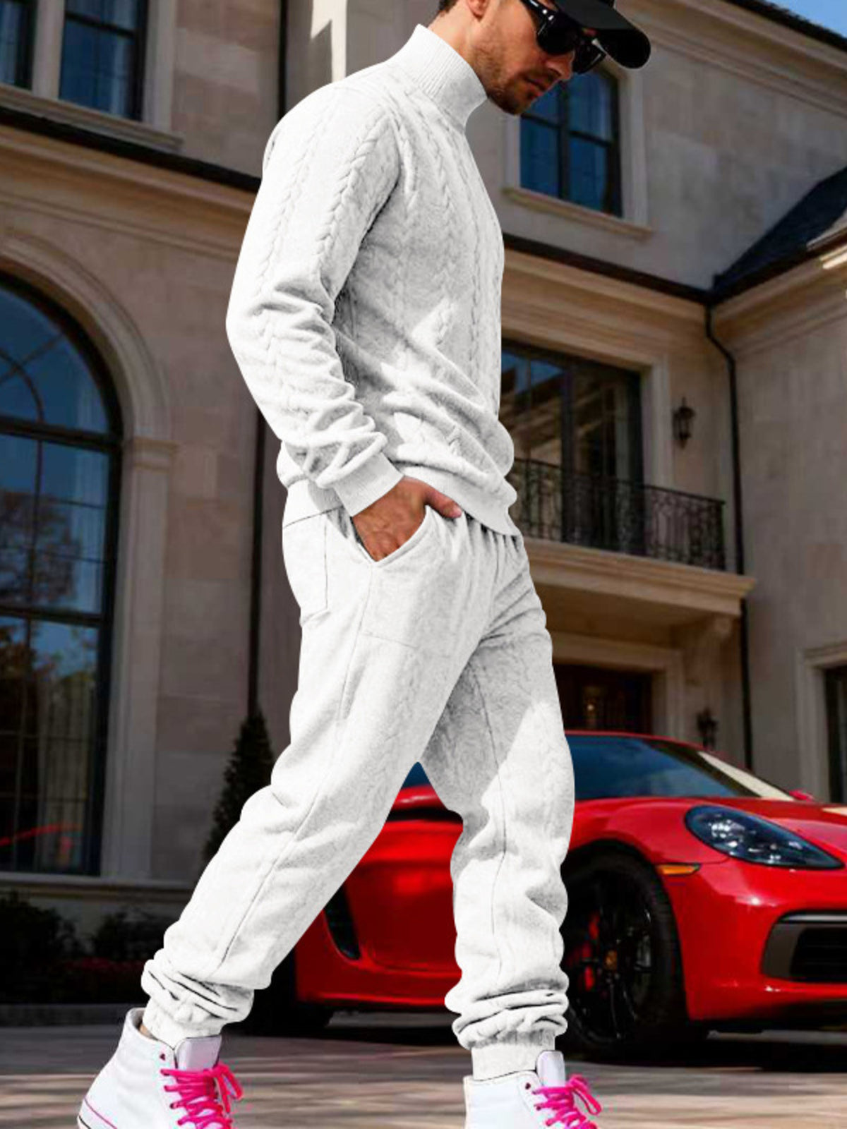 White cable-knit sweater and joggers worn from the side.