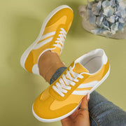 Yellow striped flat shoes held up to show the sides and soles