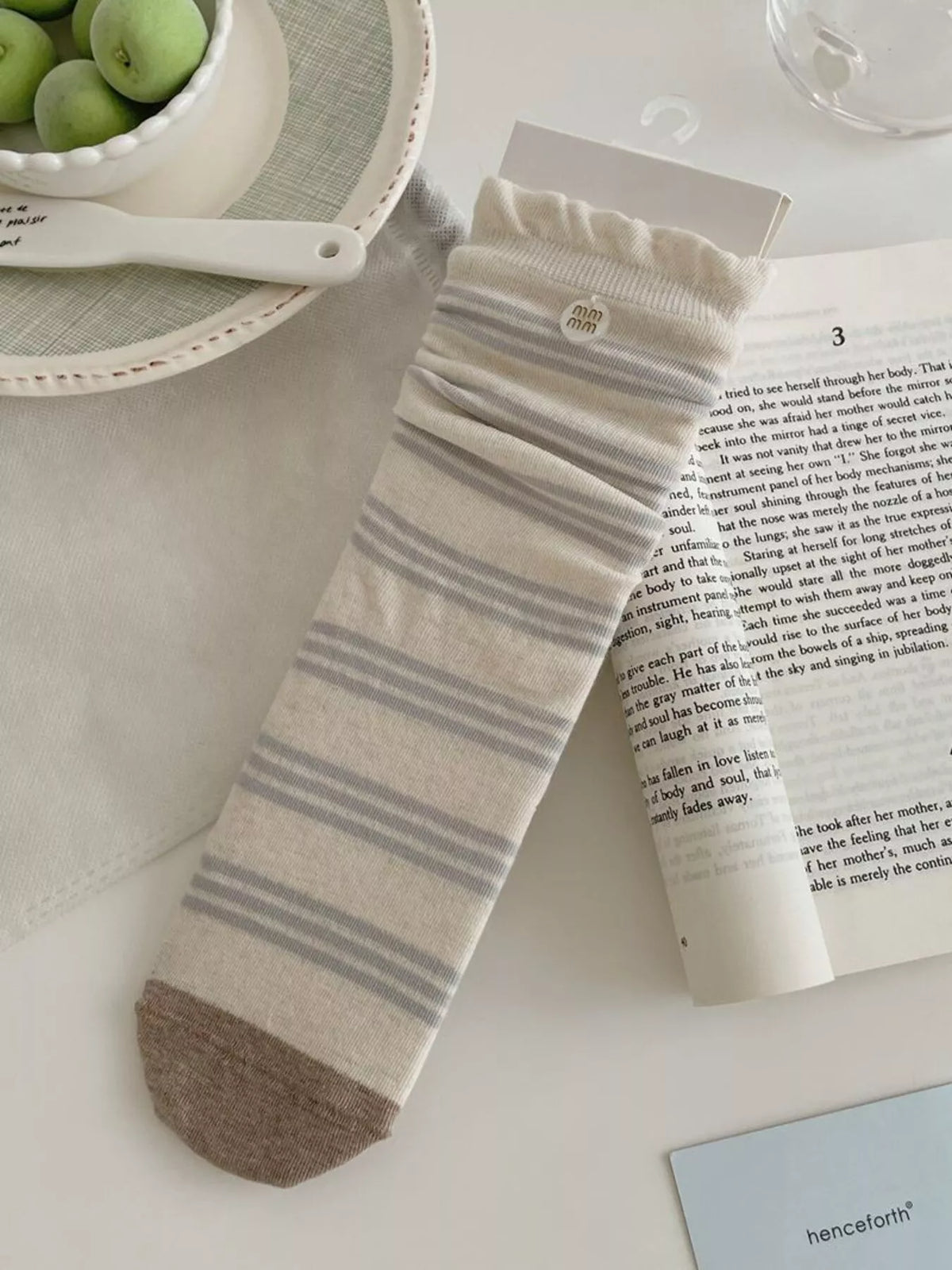 Cream sock with gray argyle band shown at mid-calf height