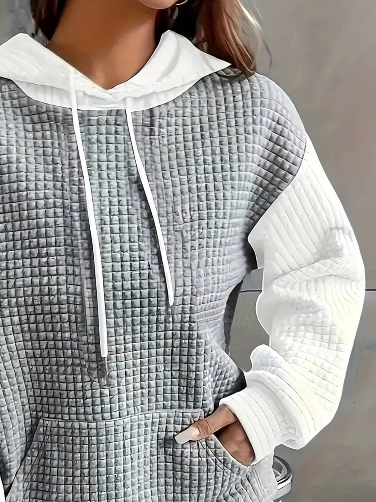 Close view of grey and white textured color-block hoodie