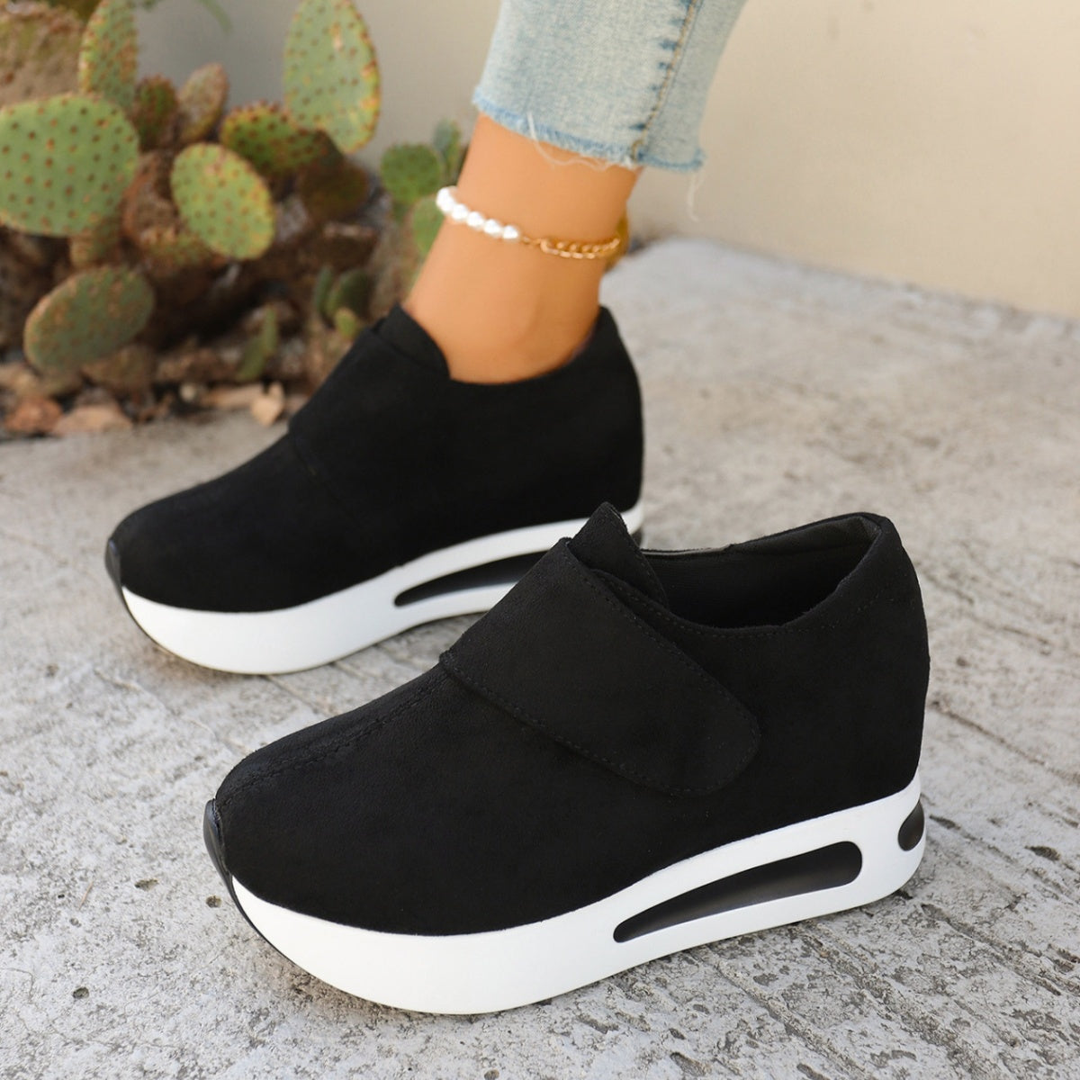 Pair of black slip-on platform sneakers, side view