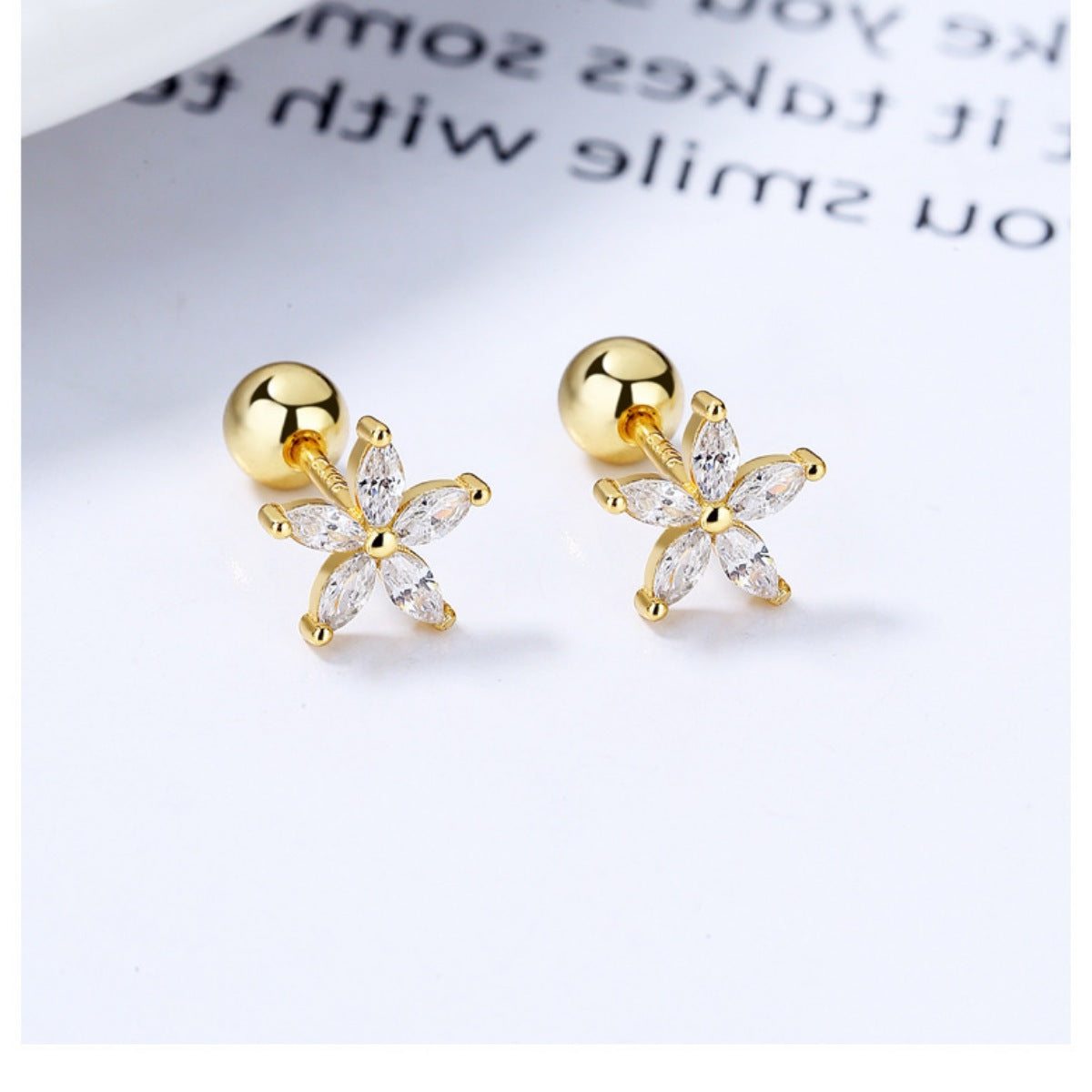 Pair of gold-tone flower studs with clear stones, front view