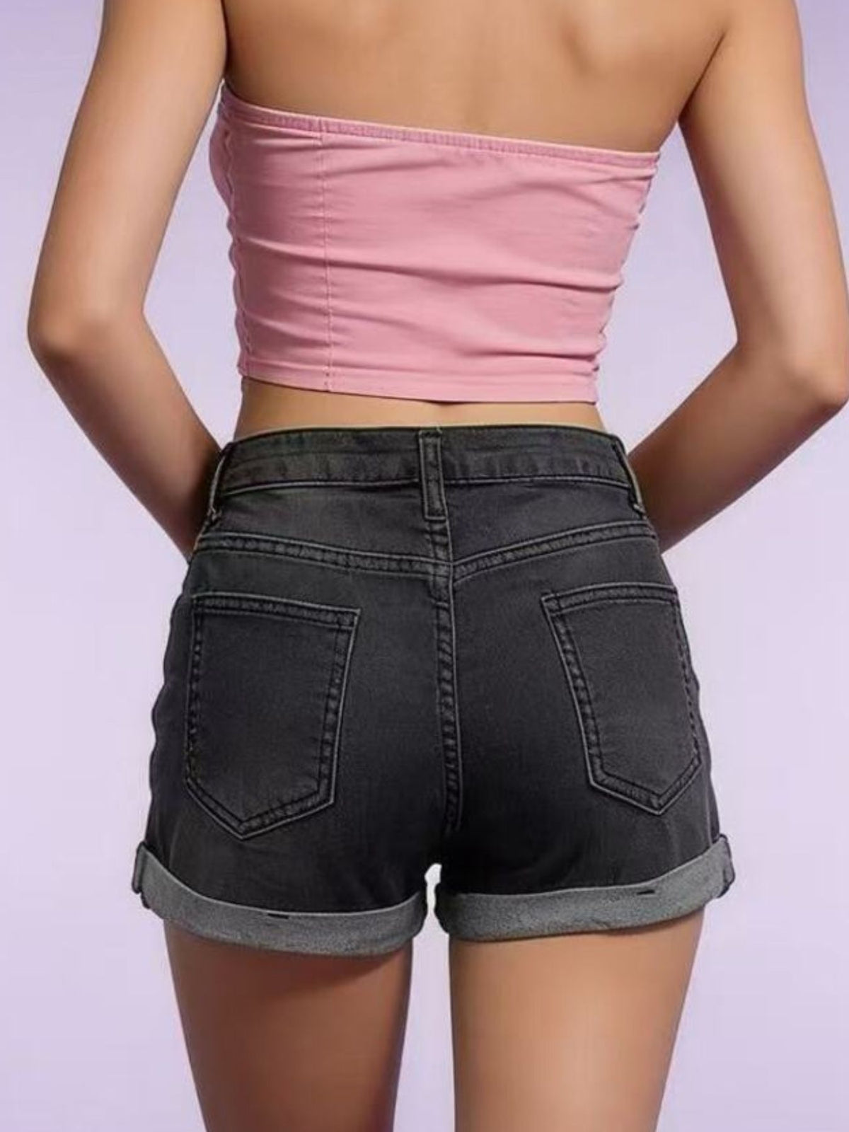 Model wearing black denim shorts with rolled hems