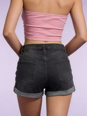 Model wearing black denim shorts with rolled hems