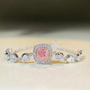 Silver-tone jewelry chain with a square blush-pink center stone, clear halo and round side stones