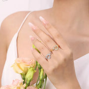 Gold-tone and silver-tone heart rings worn on a hand holding flowers