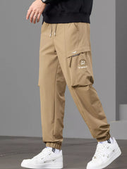 Angled front view of tan joggers showing the zip detail on the cargo pocket.