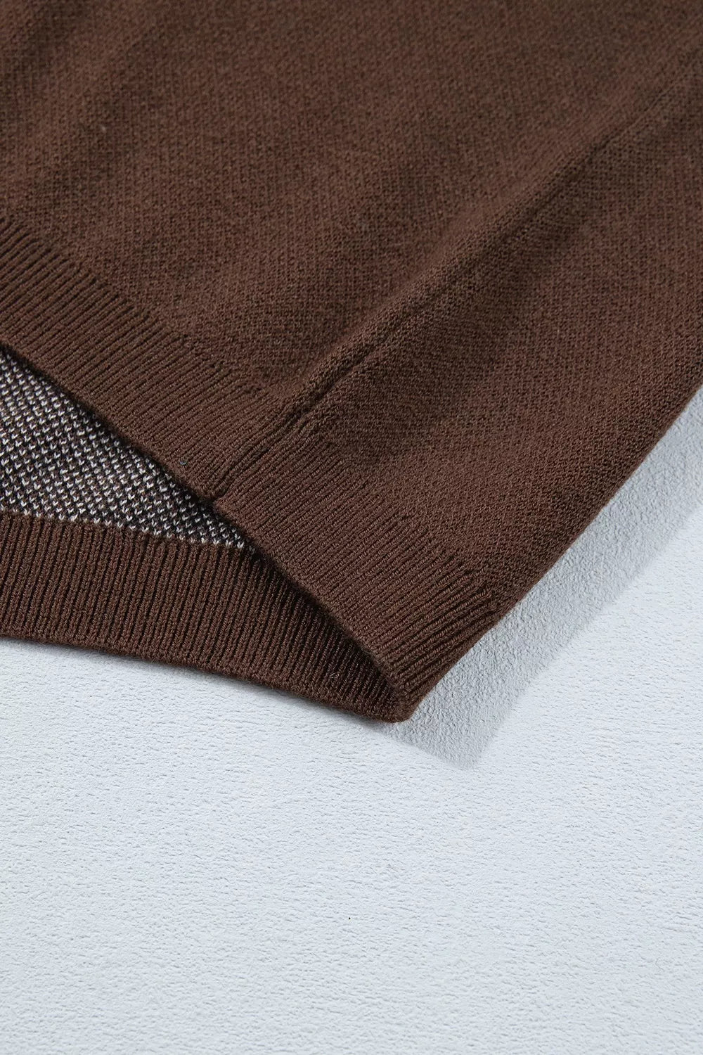Close-up of brown tee sleeve hem showing stitching and underside