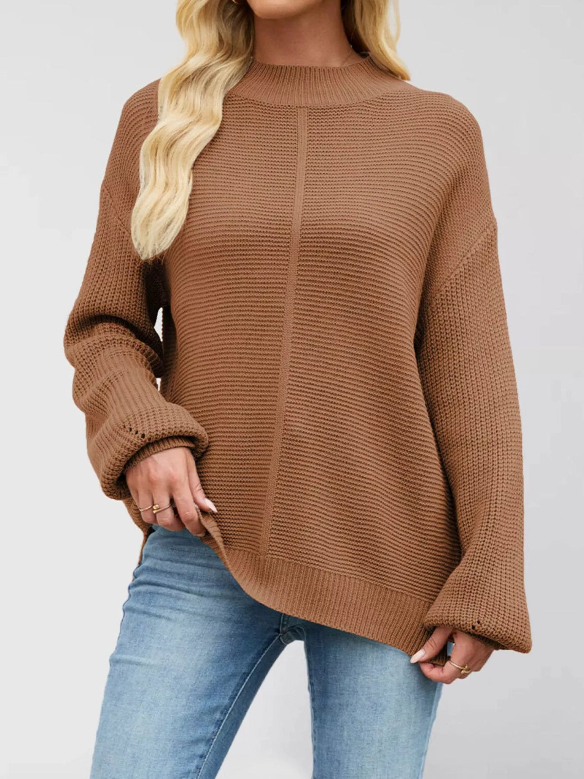 Women’s ribbed mock-neck drop-shoulder sweater in brown front view with hand at hip