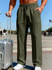 Front view of charcoal wide-leg drawstring pants beside a suitcase outdoors.