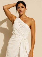 Front view of white one-shoulder mini dress with draped wrap front and side waist tie