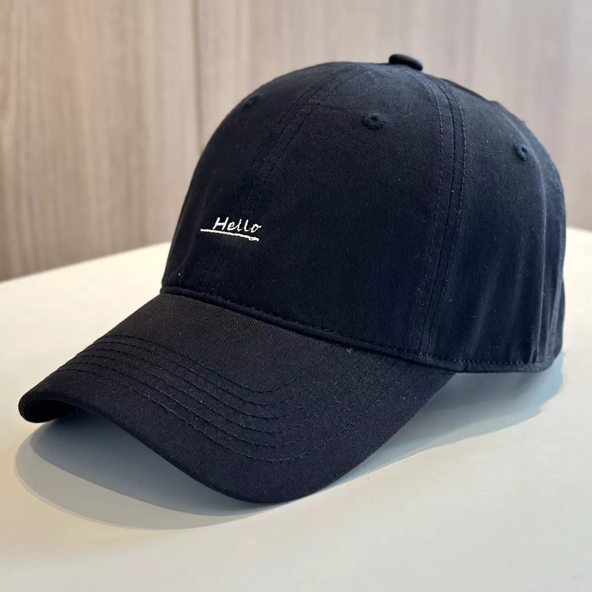 Black cotton baseball cap with small Hello embroidery on front
