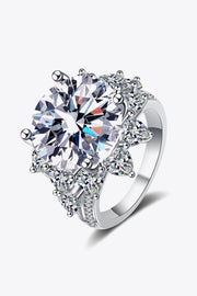 Angled close-up of silver flower-shaped moissanite ring with surrounding stones