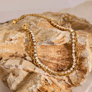 Gold double-chain bracelet arranged on a surface
