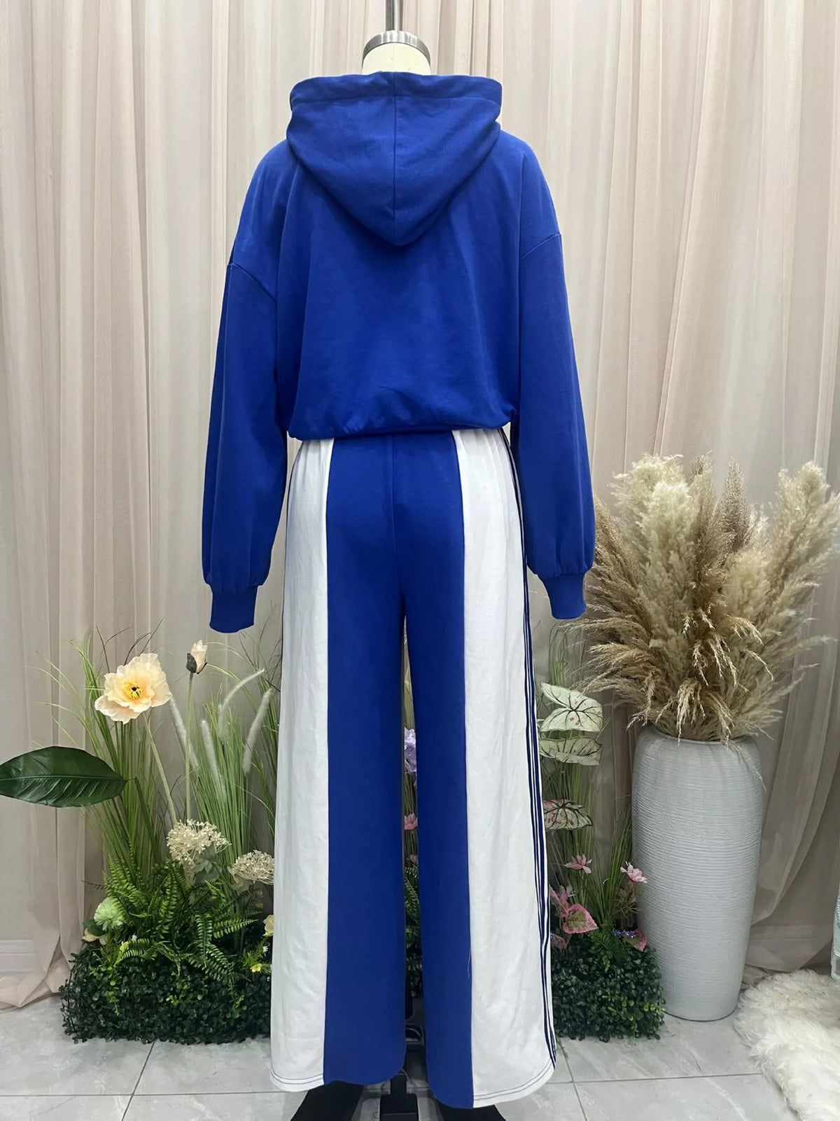 Back view of the blue hoodie and white-panel wide-leg pants on a dress form.