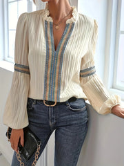 Notched textured balloon-sleeve blouse in cream striped front view with handbag