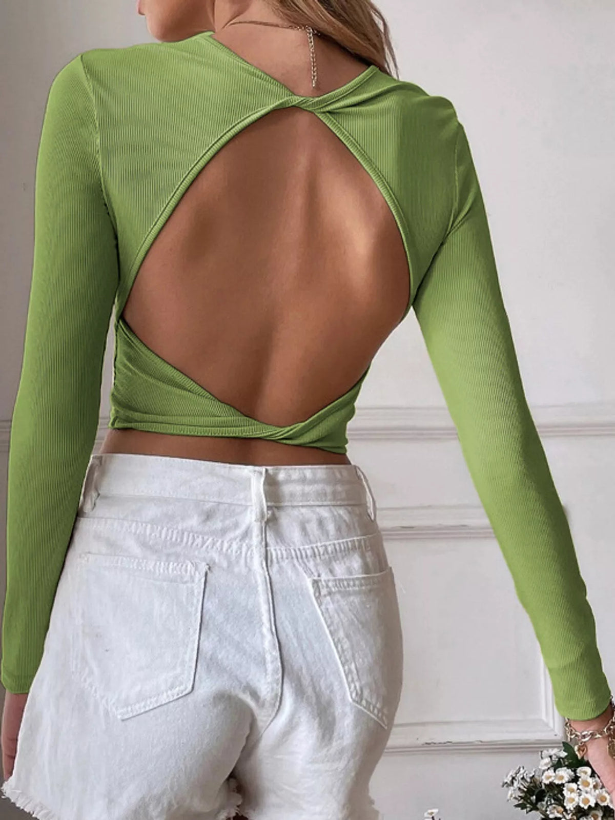 Back view of the green crop top with a large open cutout